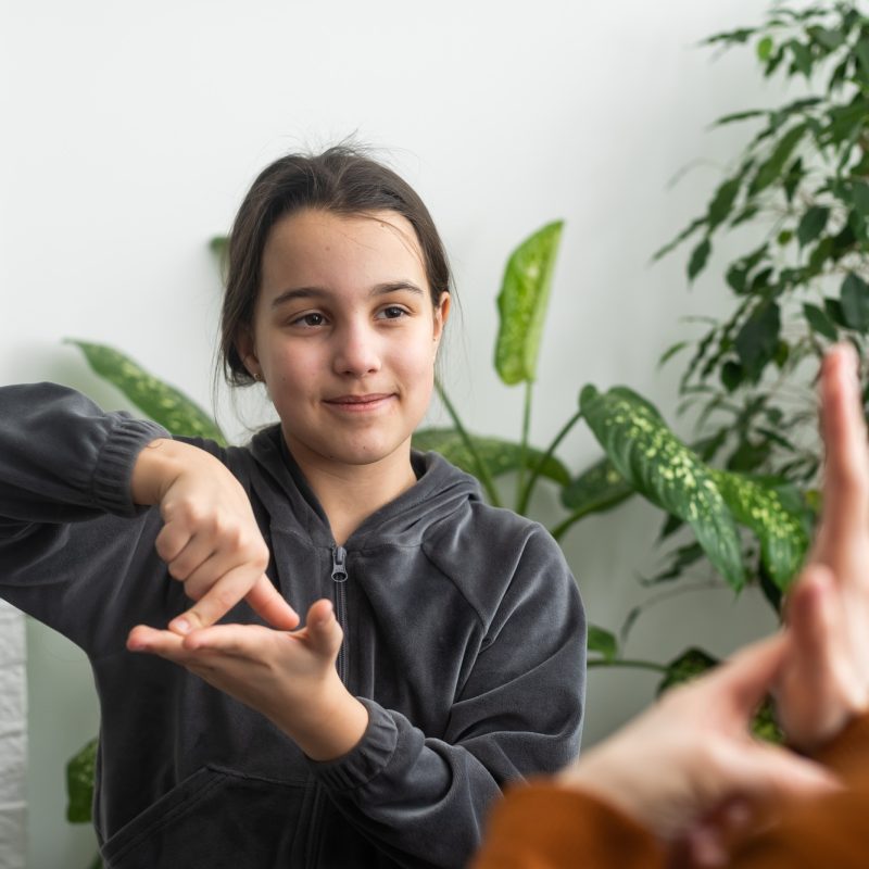 Small Caucasian teen girl child do articulation exercises with caring mother or teacher at home Small Caucasian teen girl child do articulation exercises with caring mother or teacher at home